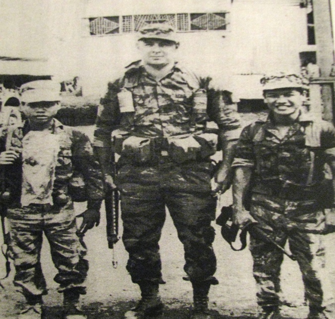 He towers over a couple of his Montagnard commandos while serving in Laos during the "Secret War" of the early 1970s. The little commando on his right was Poole's radio operator. The commando on his left was his interpreter. Photo provided