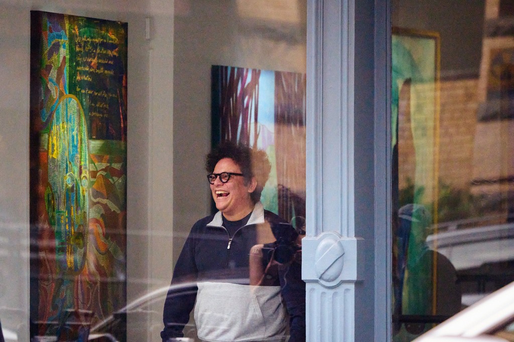 Georges Berges hysterically laughs at the front window of the Georges Berges Gallery.